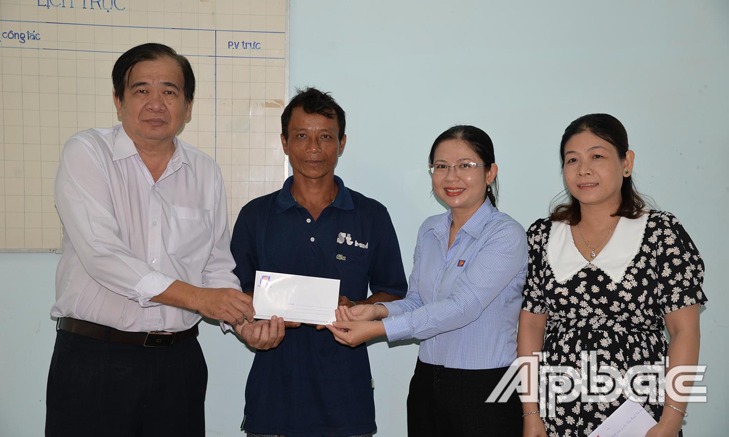 Đại diện  Công ty Xăng dầu Tiền Giang trao tiền hỗ trợ phẫu thuật cho gia đình em Tuyên.