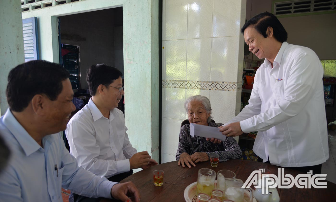 Đồng chí Nguyễn Văn Danh ân cần thăm hỏi, tặng quà bà Võ Thị Ba là vợ liệt sĩ, ở ấp 2, xã An Hữu.