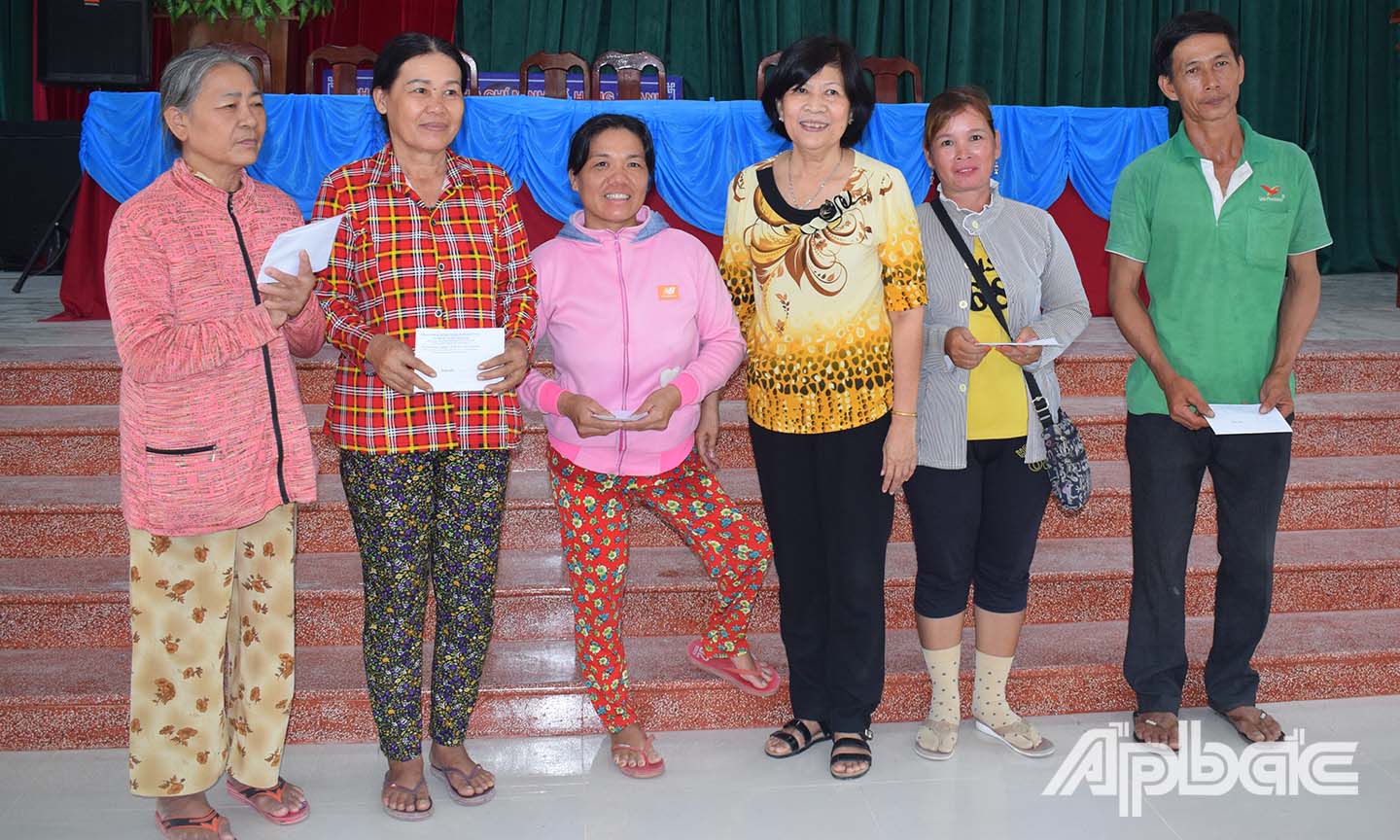 Chủ tịch Hội Bảo trợ Võ Thị Chín (thứ ba từ phải sang) trao quà cho các hộ dân.