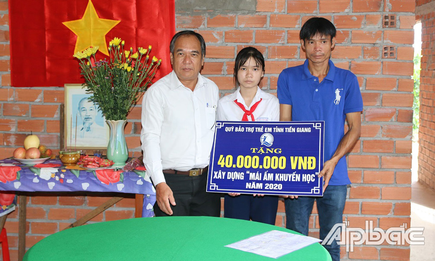 Phó Giám đốc Sở LĐ-TB- XH Phan Thanh Vân  trao trao bảng tượng trưng cho em Cẩm Tuyết và cha.