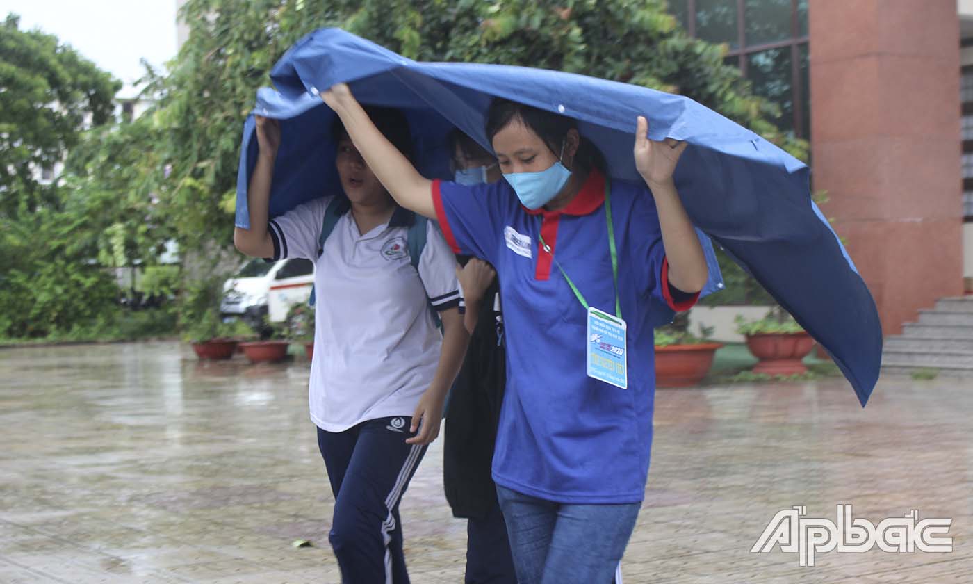 Thanh niên tình nguyện giúp TS ra khỏi trường thi vì trời mưa. 