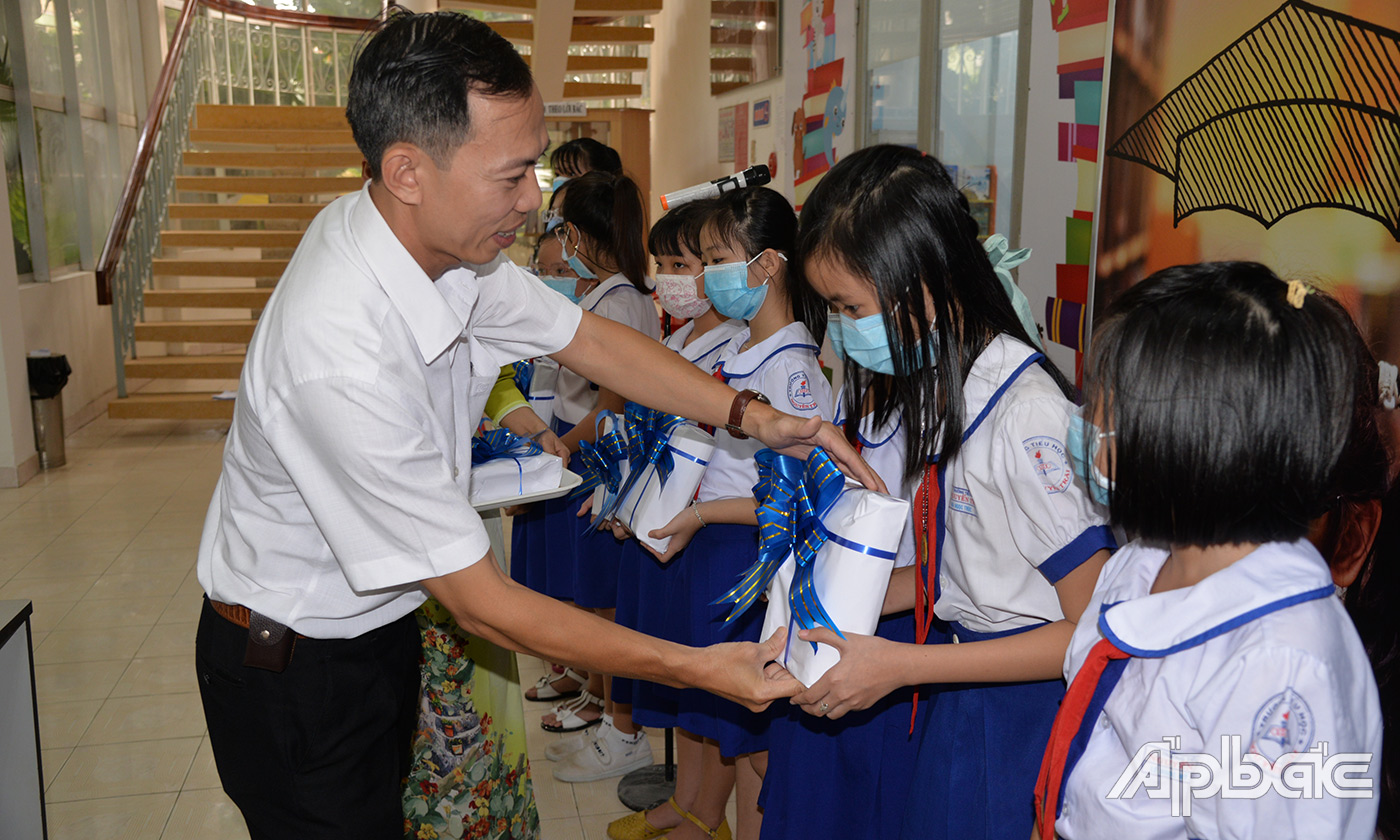 Lãnh đạo Thư Viện Tiền Giang và lãnh đạo Shinhan Finance trao sách cho các em học sinh
