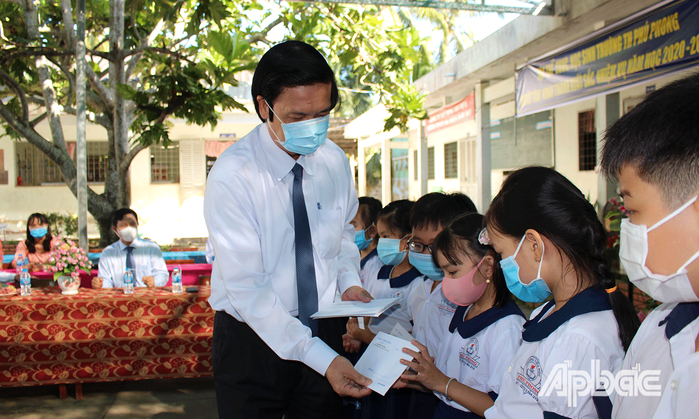 Đồng chí Nguyễn Văn Danh tặng học bổng cho học sinh. 