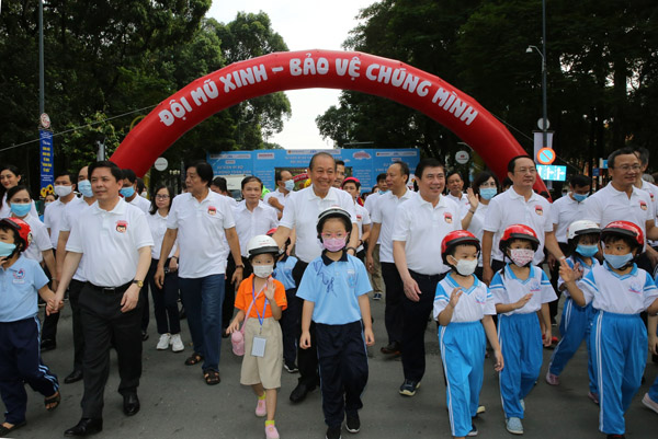 Các đại biểu và và các em học sinh tại sự kiện đi bộ vận động toàn dân đội mũ bảo hiểm cho trẻ em. Ảnh: VGP/Mạnh Hùng