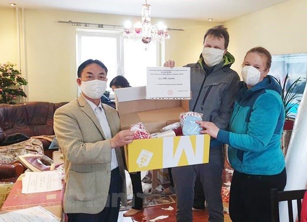 Trinh Tan (L) presents masks in North Morava (Photo: VNA)