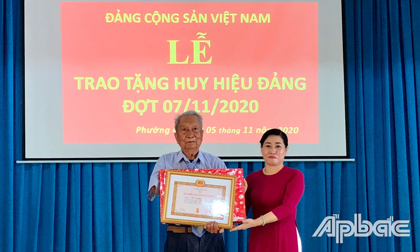 Đồng chí Châu Thị Mỹ Phương trao Huy hiệu 60 năm tuổi Đảng cho đảng viên Võ Văn Trị.