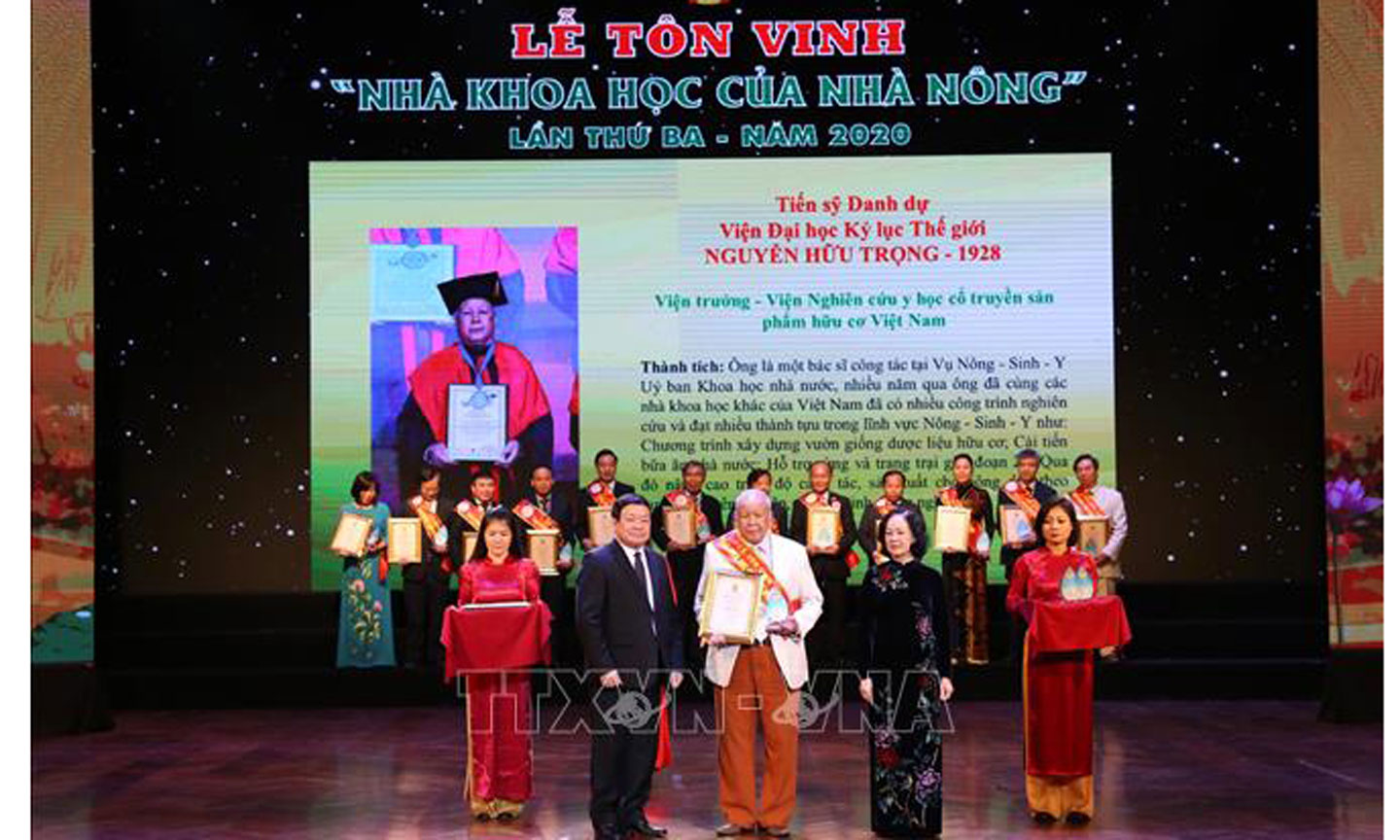 Trưởng Ban Dân vận Trung ương Trương Thị Mai và Chủ tịch Ban chấp hành trung ương Hội Nông dân Việt Nam Thào Xuân Sùng trao Giấy chứng nhận và Kỷ niệm chương cho các nhà khoa học. Ảnh: TTXVN 