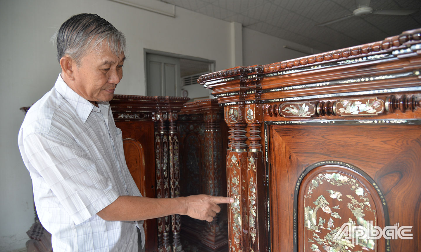 Ông Nguyễn Công Thành giới thiệu những nét độc đáo của việc khảm xà cừ trên chiếc tủ thờ Gò Công.