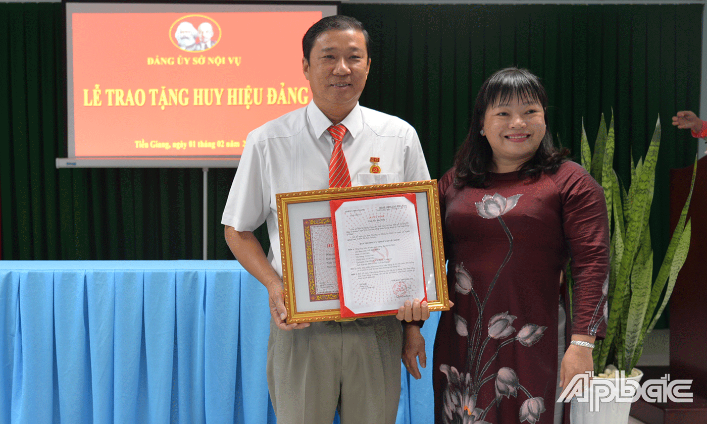 Đồng chí Thái Ngọc Bảo Trâm trao huy hiệu cho đồng chí Võ Tấn Hiền.