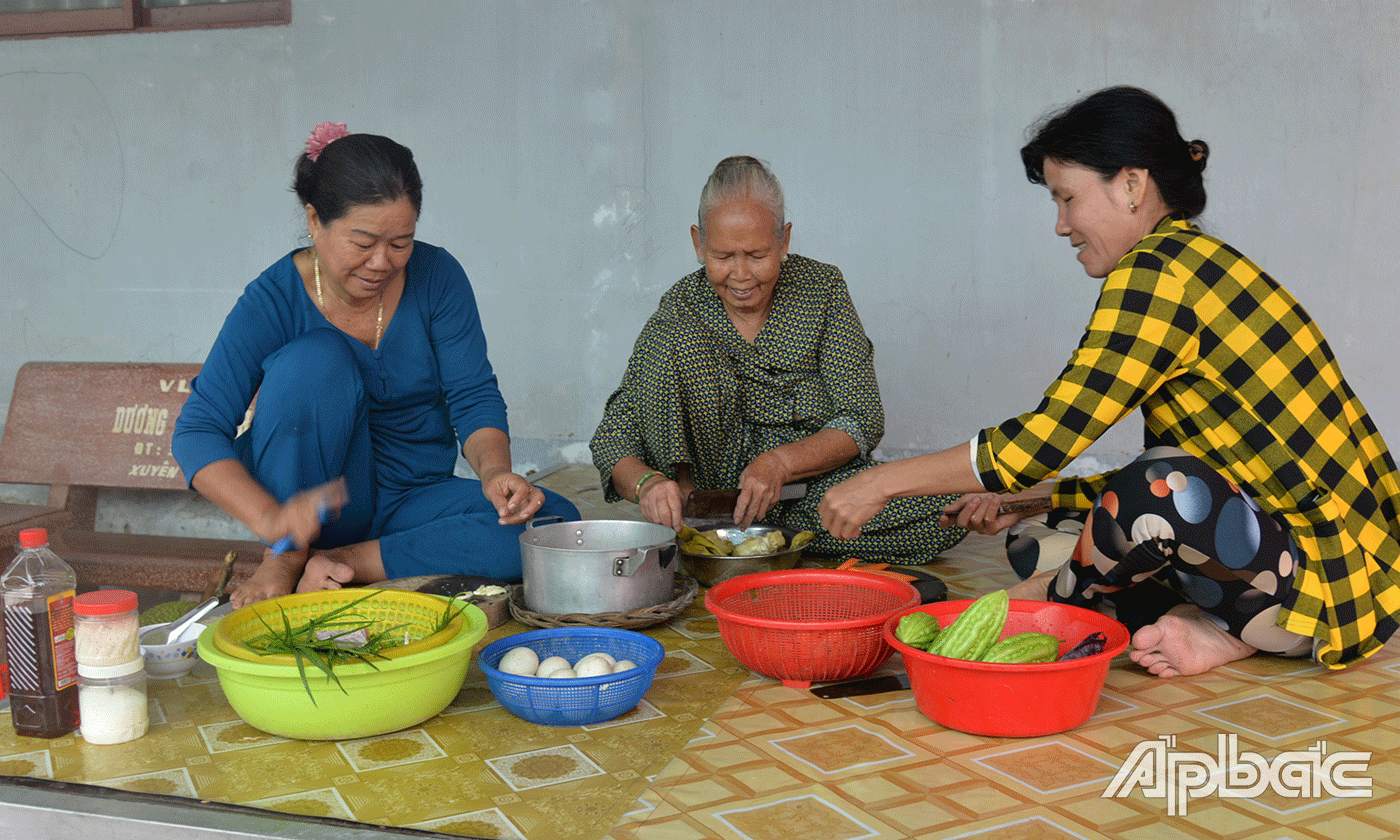 Bà Tạm cùng 2 con dâu của mình rửa thịt, rau củ, sơ chế, chuẩn bị nấu ăn.