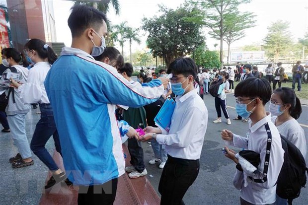 Thí sinh được đo nhiệt độ, rửa tay sát khuẩn trước khi vào thi tại điểm thi Trường Đại học Công nghệ Thành phố Hồ Chí Minh (cơ sở thành phố Thủ Đức). (Ảnh: Thu Hoài/TTXVN)
