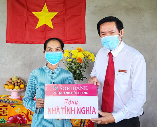 Phó Giám đốc Agribank Tiền Giang Trương Văn Đoàn trao biển tượng trưng tặng nhà tình nghĩa cho gia đình bà Dợt.