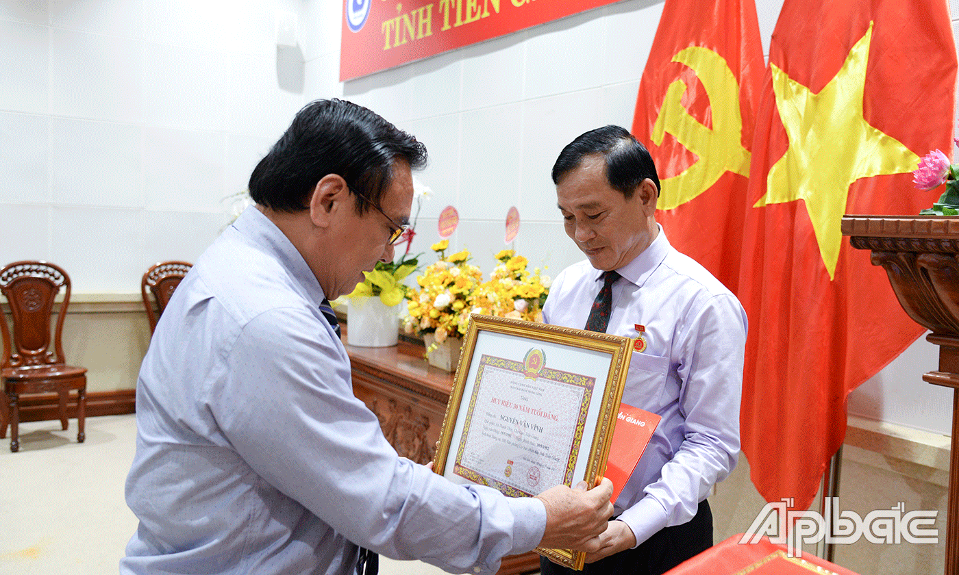 Đồng chí Võ Văn Bình trao Huy hiệu Đảng cho đảng viên Nguyễn Văn Vĩnh.