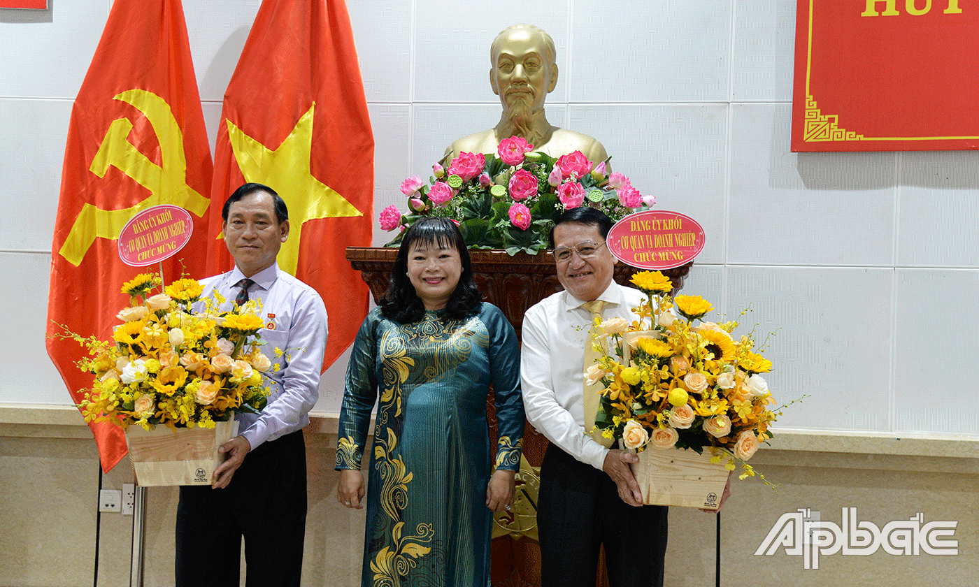 Đồng chí Thái Ngọc Bảo Trâm tặng hoa chúc mừng 2 đảng viên.
