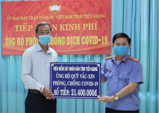 đồng chí Đoàn Tấn Minh trao số tiền ủng hộ Quỹ Vắc - xin phòng chống Covid-19 đến đại diện Ủy ban Mặt trận Tổ quốc Việt Nam tỉnh Tiền Giang.