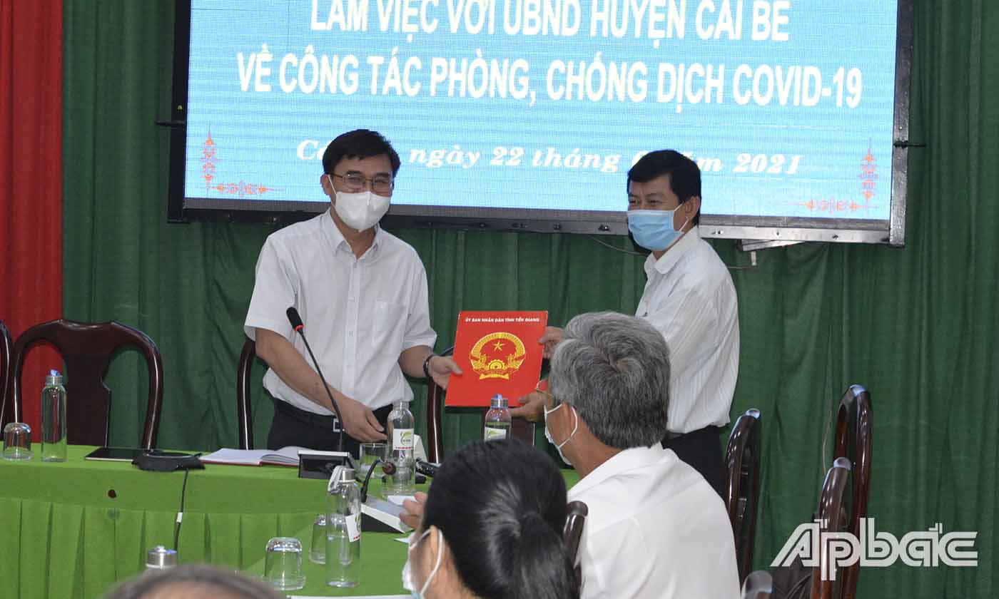 Đồng chí Nguyễn Văn Mười trao quà của Thường trực UBND tỉnh đến lãnh đạo UBND huyện Cái Bè.