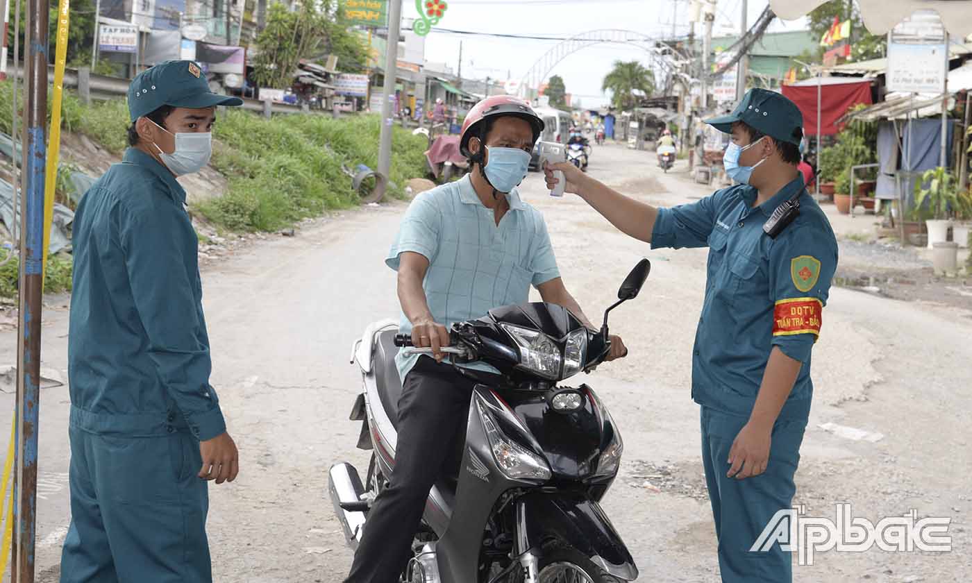 Kiểm tra thân nhiệt người dân tại chốt kiểm tra y tế tại chợ Tân Thanh, huyện Cái Bè.