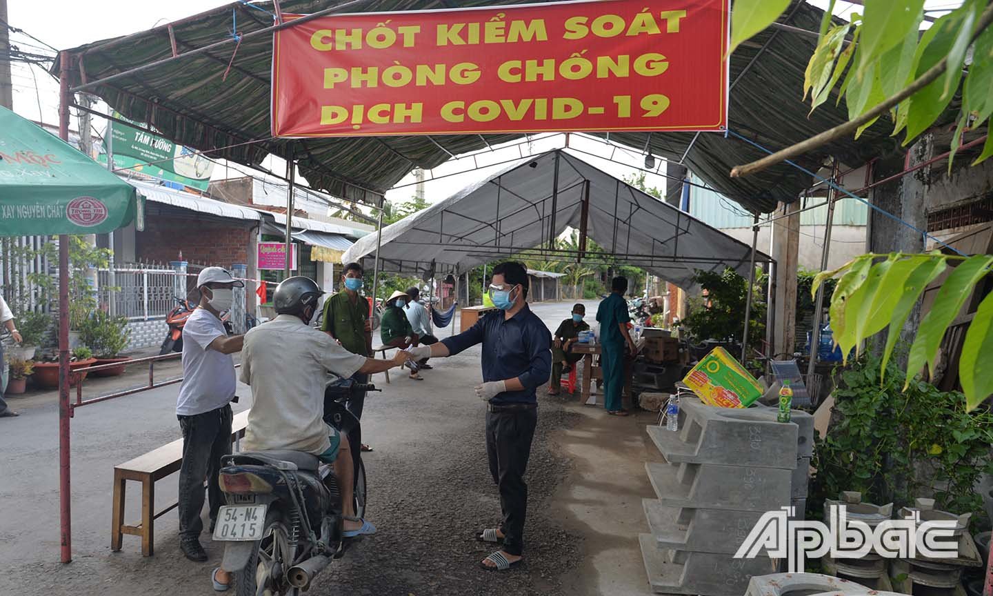 Kiểm soát y tế và kiểm tra phiếu đi chợ của người dân tại chợ Long Định.