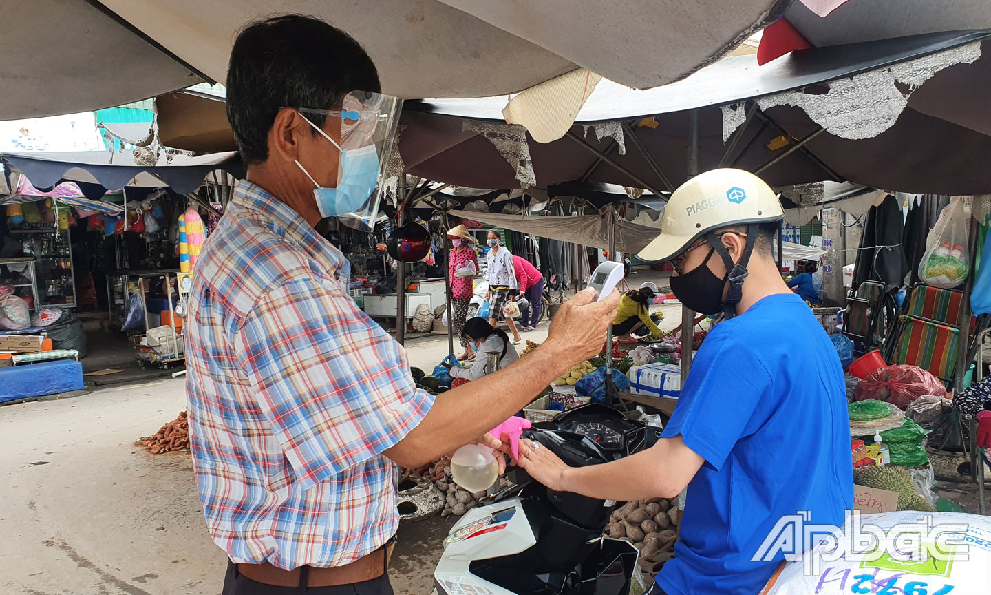 Người dân ra vào chợ Hòa Khánh được đo thân nhiệt, rửa tay sát khuẩn.