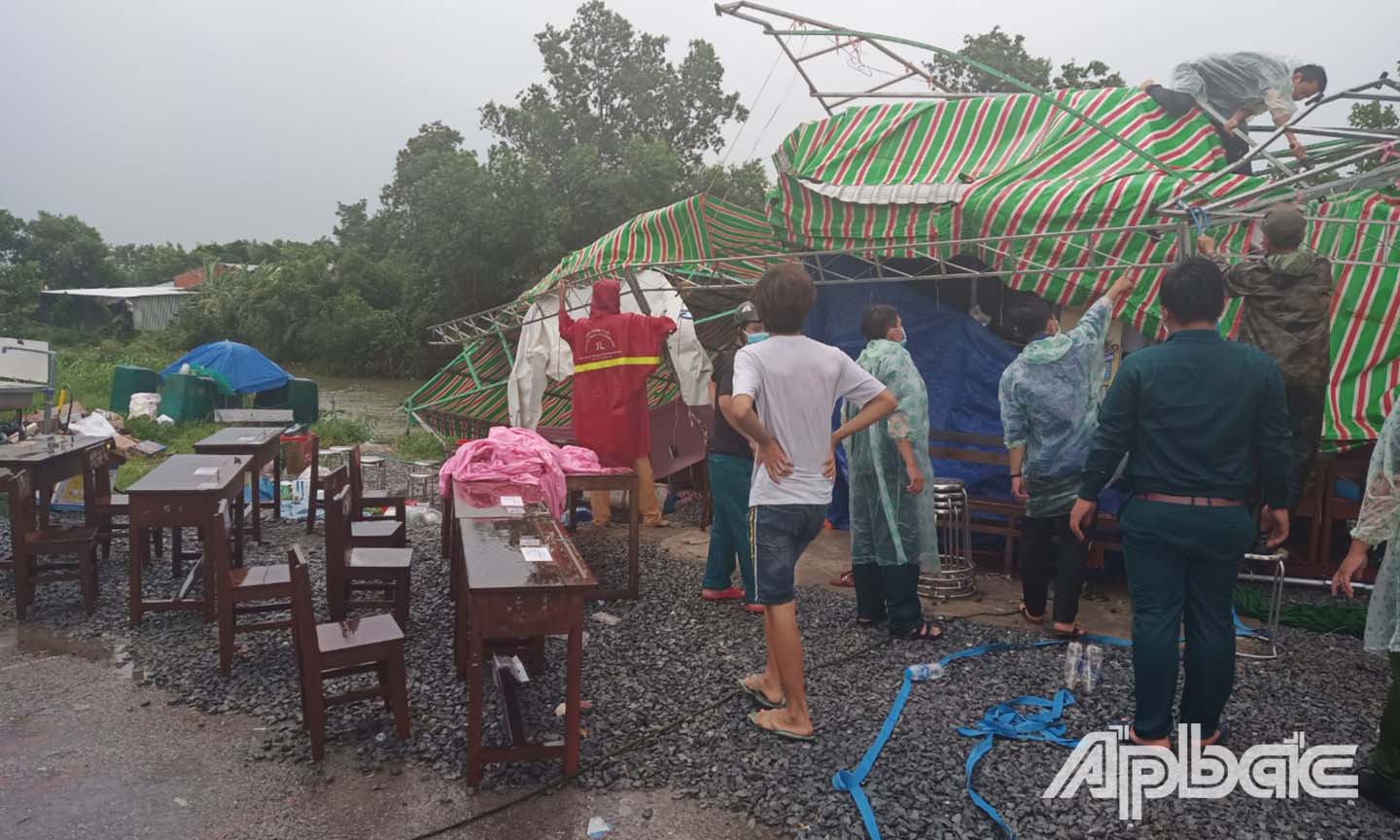 Các thành viên tại một chốt kiểm soát cơ sở ở huyện Tân Phước sửa chửa lại mái che dã chiến sau cơn giông lớn chiều 19-7.