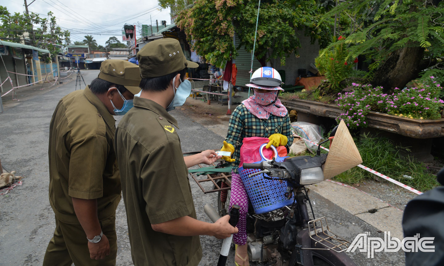 : Lực lượng làm nhiệm vụ tại chốt kiểm soát Ngã 3 Xoài Hột (xã Thạnh Phú, huyện Châu Thành) nhắc nhở người dân buôn bán phải đảm bảo an toàn phòng, chống dịch bệnh.