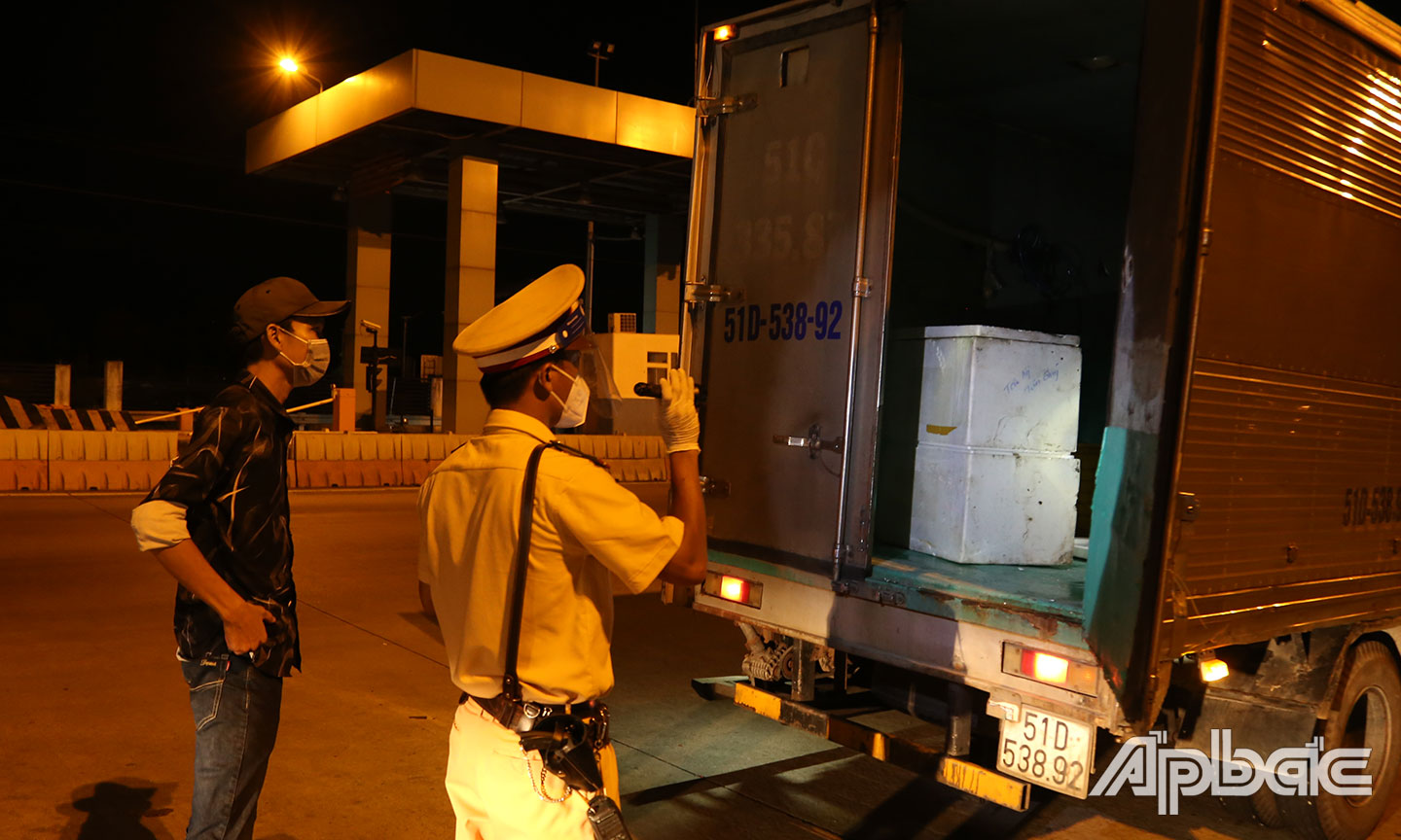 Hàng loạt xe tải buộc kiểm tra thùng hàng phía sau để đảm bảo nguyên tắc phòng chống dịch.