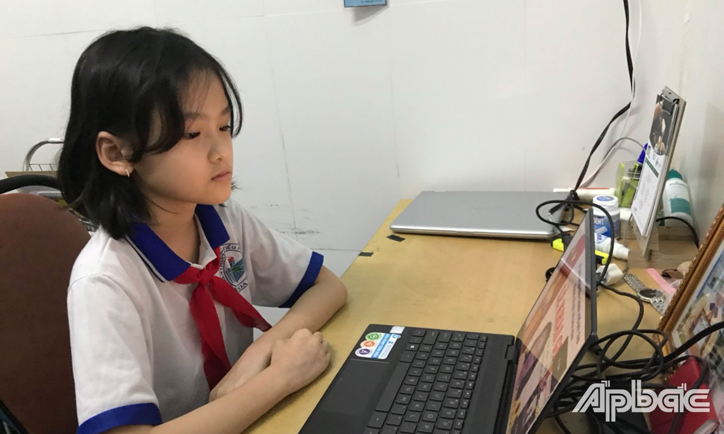 Em Văn Tú Ngọc, học sinh lớp 42, Trường Tiểu học Thủ Khoa Huân (TP. Mỹ Tho) dự Lễ khai giảng  trực tuyến năm học mới 2021 - 2022.