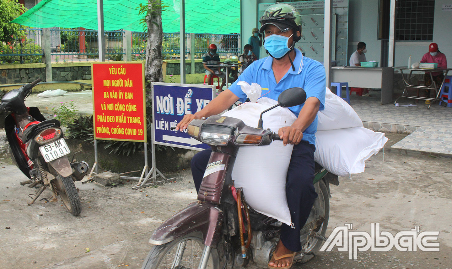 Các lực lượng xã Bình Phú hỗ trợ vận chuyển gạo đến trao tận nhà người dân.
