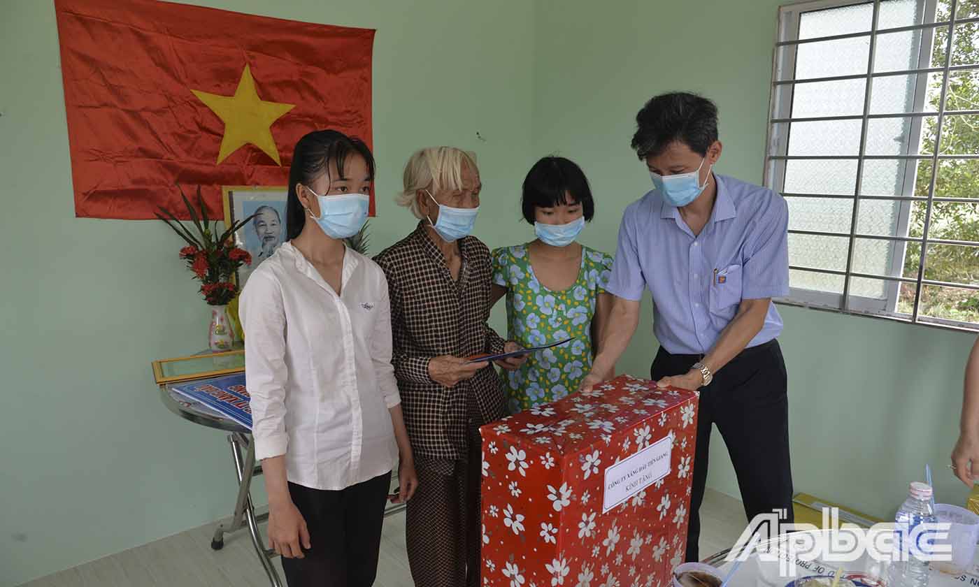 Phó Giám đốc Công ty Xăng dầu Tiền Giang Nguyễn Xuân Bình tặng quà cho gia đình bà Lê Thị Bé Ba.
