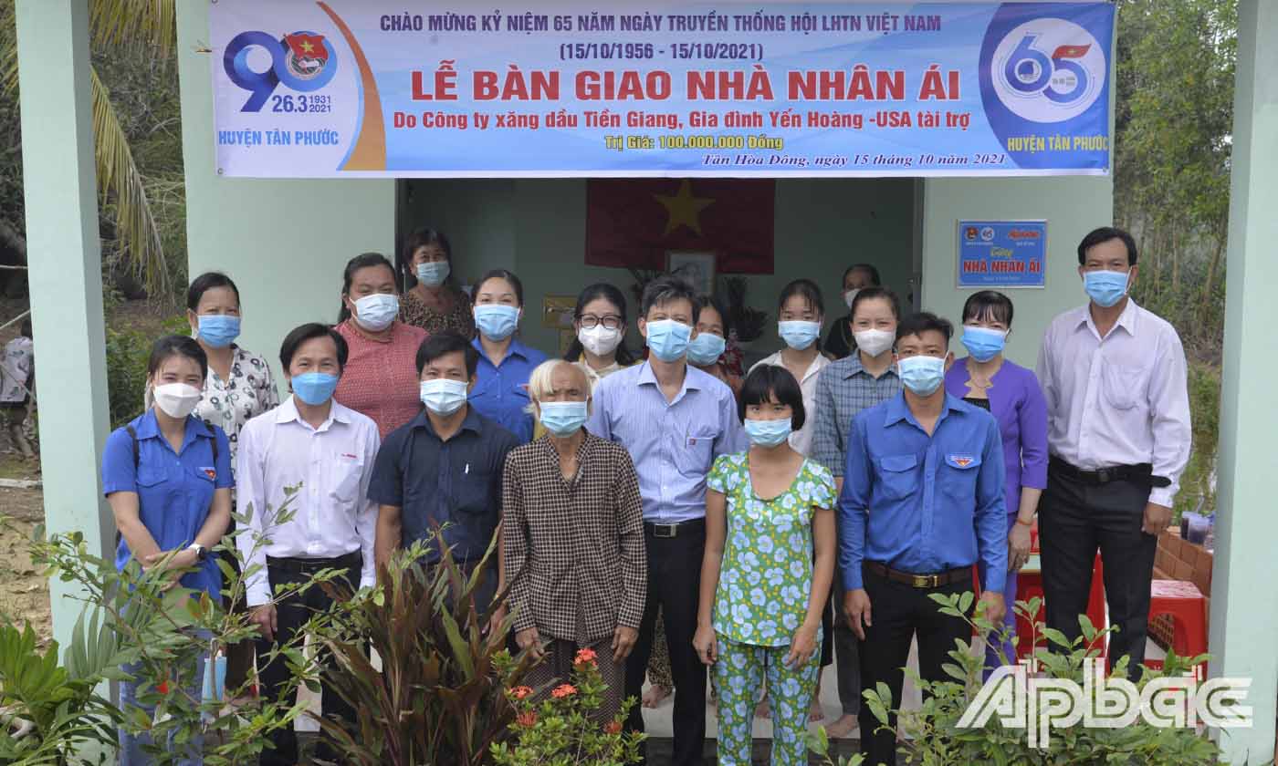 Bà Lê Thị Bé Ba chụp ảnh lưu niệm cùng các đơn vị hỗ trợ bên ngôi nhà mới.