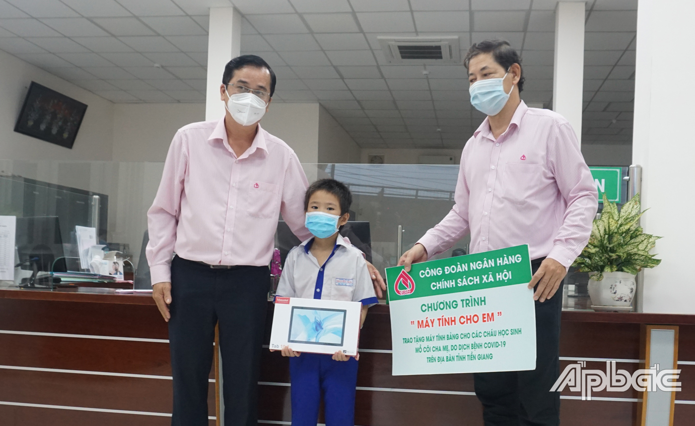 Đại diện Ngân hàng CSXH Tiền Giang trao tặng bảng tượng trưng cho học sinh.