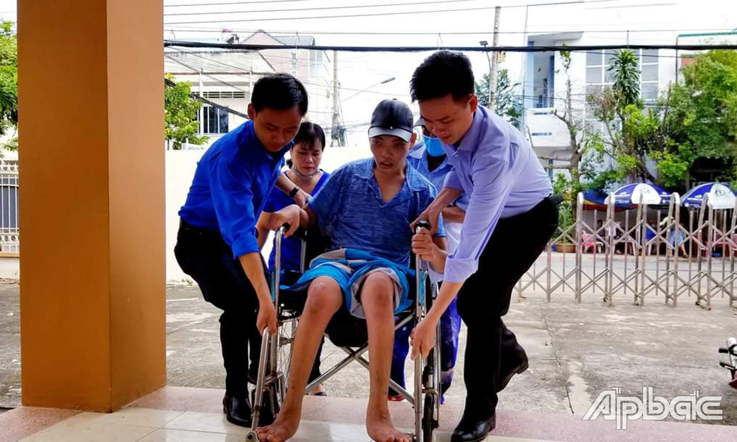 Anh Luân hỗ trợ thanh niên khuyết tật (ảnh chụp trước khi dịch Covid-19 bùng phát). 