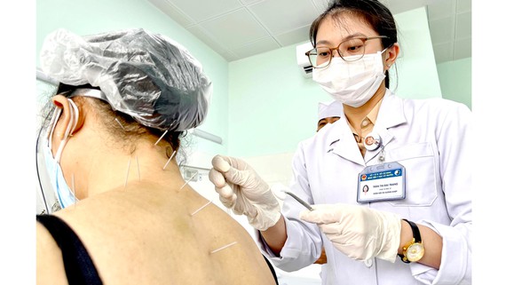 ThS-BS Trần Thị Đài Trang, khoa Nội cơ xương khớp Bệnh viện Y học cổ truyền TPHCM châm cứu cho bệnh nhân điều trị hậu Covid-19. Ảnh: HOÀNG HÙNG