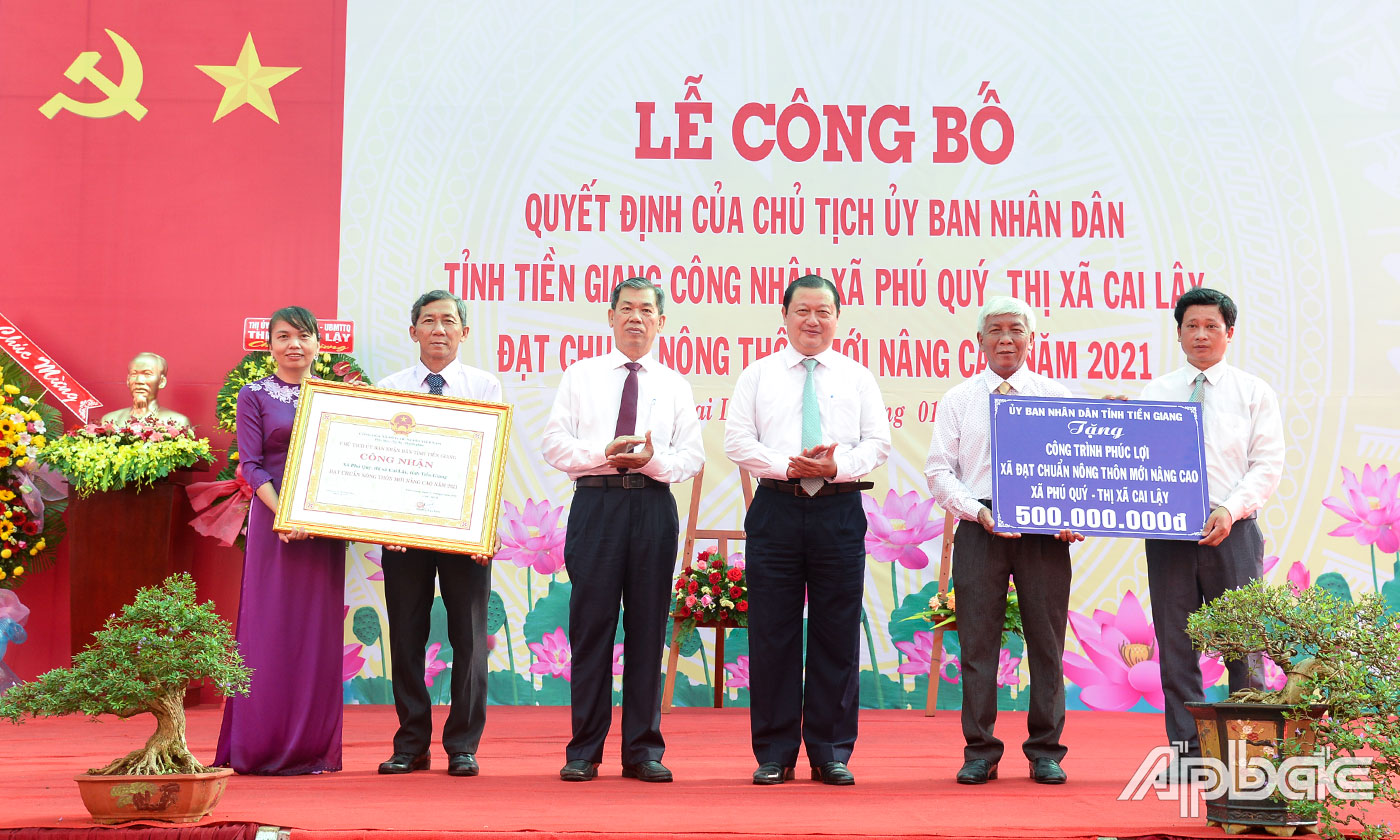 Đồng chí Nguyễn Văn Mẫn và đồng chí Phan Phùng Phú trao Bằng công nhận đạt chuẩn NTM nâng cao và Bảng tượng trưng tặng công trình phúc lợi cho xã Phú Quý.