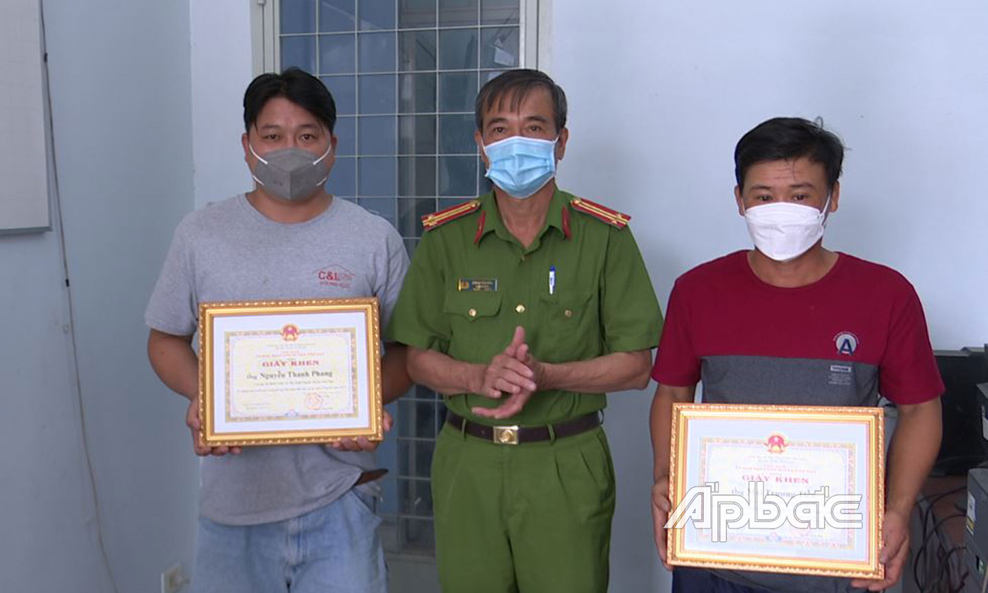 Công an huyện Chợ Gạo trao giấy khen của UBND huyện cho 2 anh Phang  và Tiễn.    