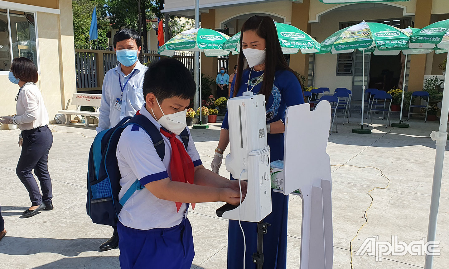 Học sinh đến trường tuân thủ các biện pháp phòng, chống dịch Covid-19. Ảnh chụp tại Trường Tiểu học Nguyễn Trãi, TP. Mỹ Tho. 