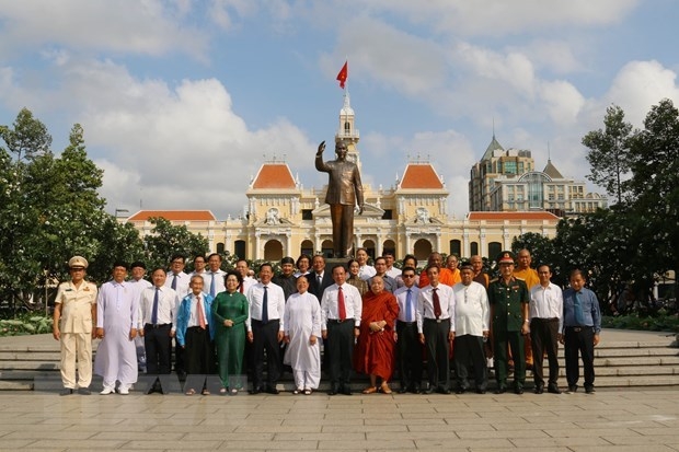 Delegates pose for a group photo with a statue of President Ho Chi Minh (Photo: VNA).