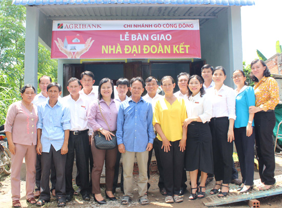 Nhà tài trợ và chính quyền địa phương chụp ảnh lưu niệm tại ngôi nhà mới của ông Trần Văn Tý ngụ xã Tân Đông, huyện Gò Công Đông.