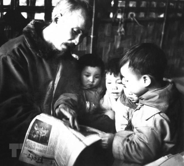 Bác Hồ đọc báo cho các cháu thiếu nhi nghe tại trại nhi đồng ở Việt Bắc, năm 1950. (Ảnh: Tư liệu/TTXVN)