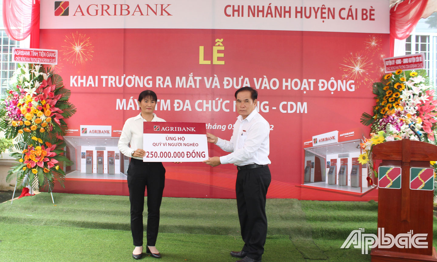 Ông Nguyễn Thế Phương, Giám đốc Agribank Cái Bè (bên phải) trao biển tượng trưng số tiền hỗ trợ 250 triệu đồng cho bà Nguyễn Hồng Ngọc, Huyện ủy viên, Phó Chủ tịch UB MTTQ VN huyện Cái Bè.