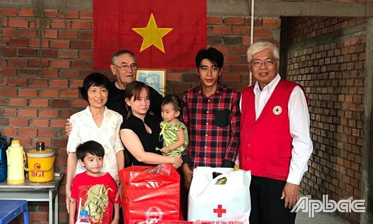 Chủ tịch Hội CTĐ tỉnh Tiền Giang Võ Văn Láng (bìa phải) trao nhà cho gia đình có hoàn cảnh khó khăn.