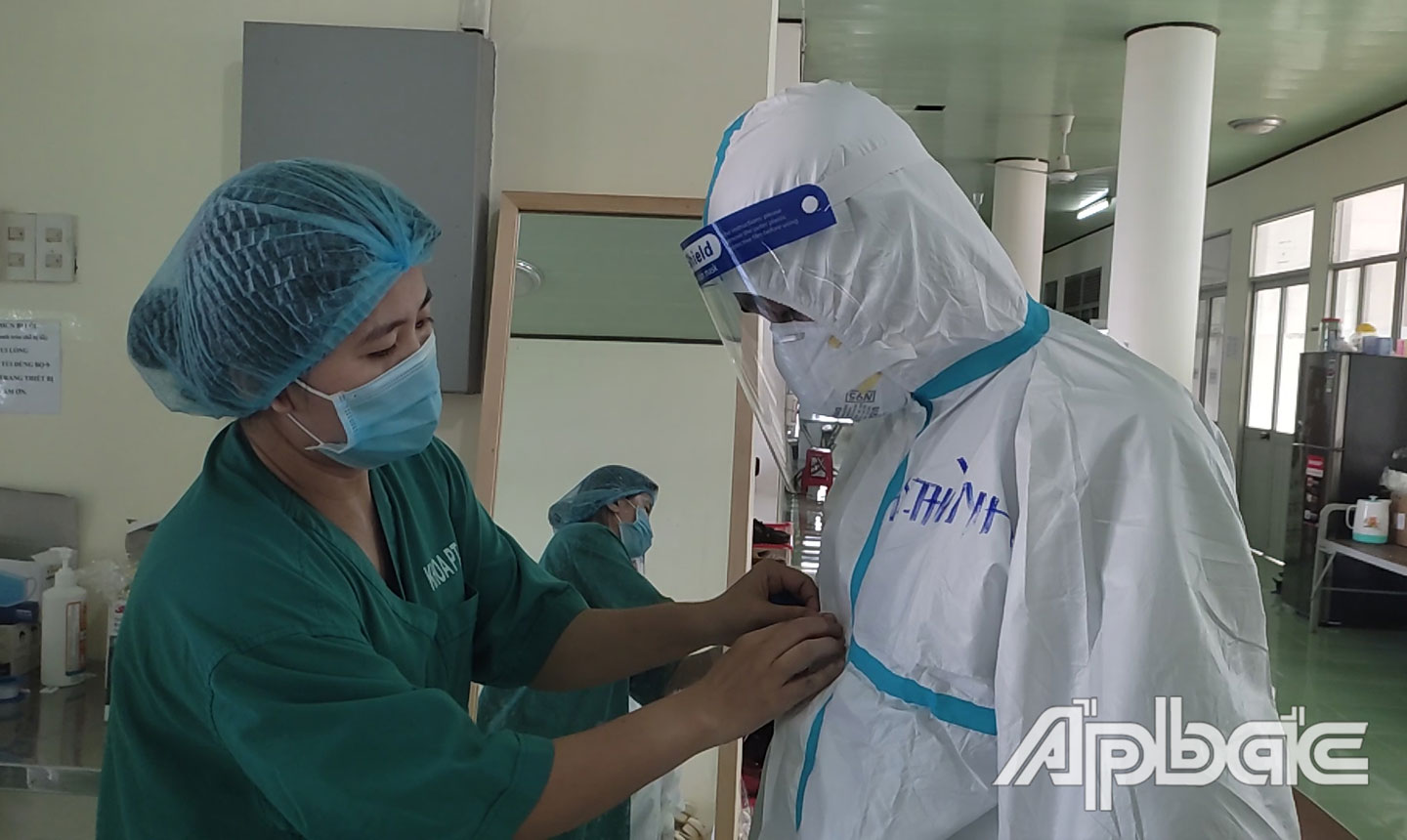 Nhân viên y tế kiểm tra phương tiện phòng hộ cá nhân của phóng viên trước khi vào Trung tâm Hồi sức bệnh nhân Covid-19 tỉnh tác nghiệp.