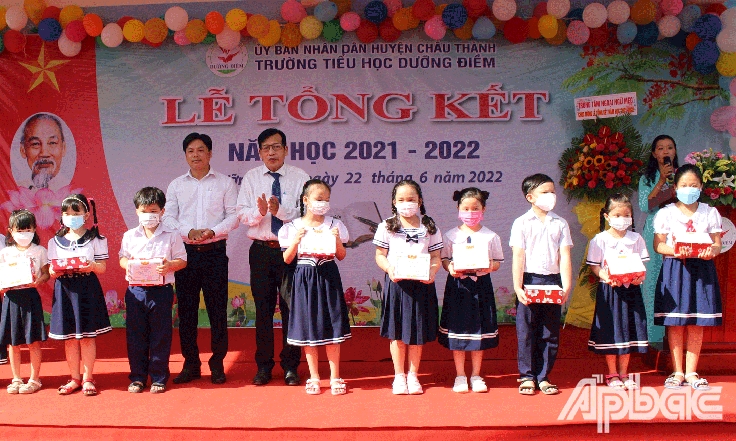 Trưởng phòng Giáo dục và Đào tạo huyện Châu Thành Võ Văn Dũng và lãnh đạo xã Dưỡng Điềm trao thưởng cho học sinh. 