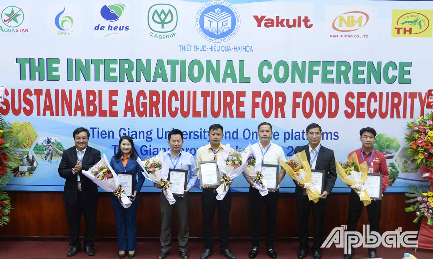 Đại diện Hội đồng Trường Đại học Tiền Giang tặng hoa cho các đại biểu, nhà khoa học tham dự hội thảo.
