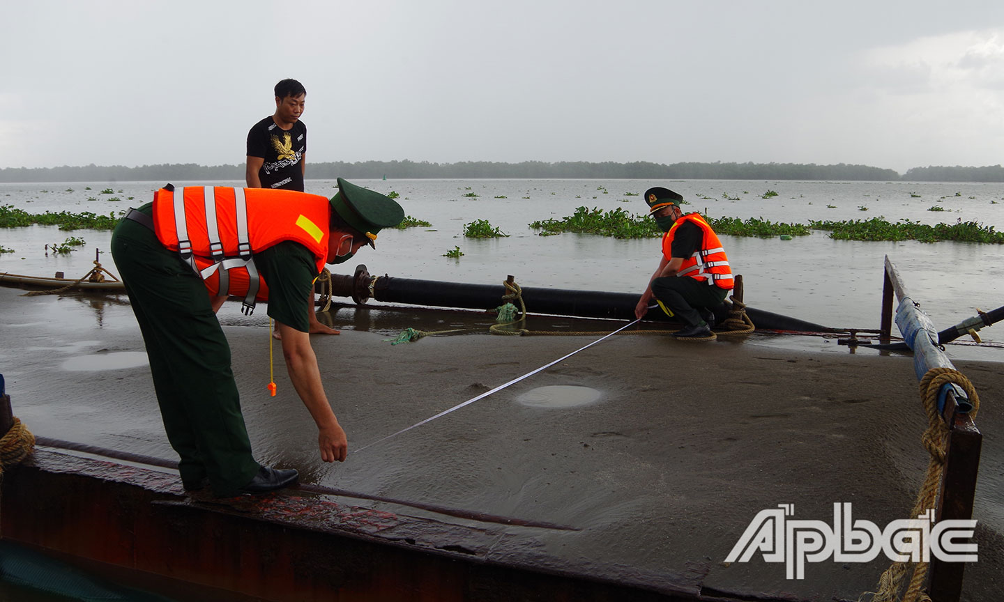 Tổ công tác Đồn Biên phòng Kiểng Phước, BĐBP Tiền Giang kiểm tra, thẩm định khối lượng cát trên phương tiện.