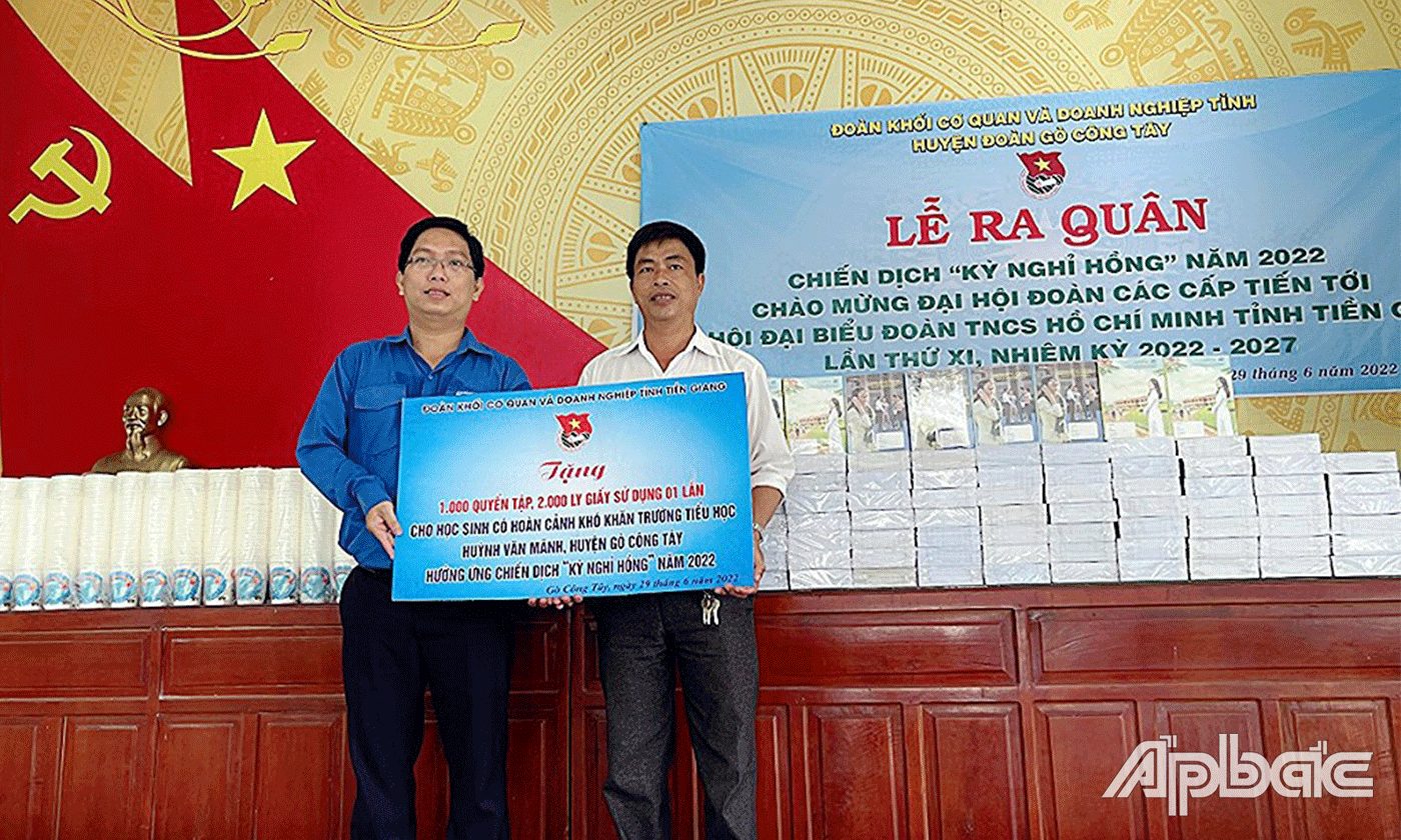 Bí thư Đoàn khố Nguyễn Xuân Phúc (bên trái ) trao tặng bảng tượng trưng tập cho trường tiểu học Huỳnh Văn Mãnh.