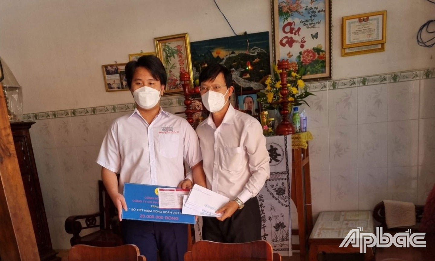 Anh Việt (bìa phải) trao sổ tiết kiệm của CĐCS Công ty cổ phần May Công Tiến cho con CNLĐ tử vong do dịch bệnh Covid-19.