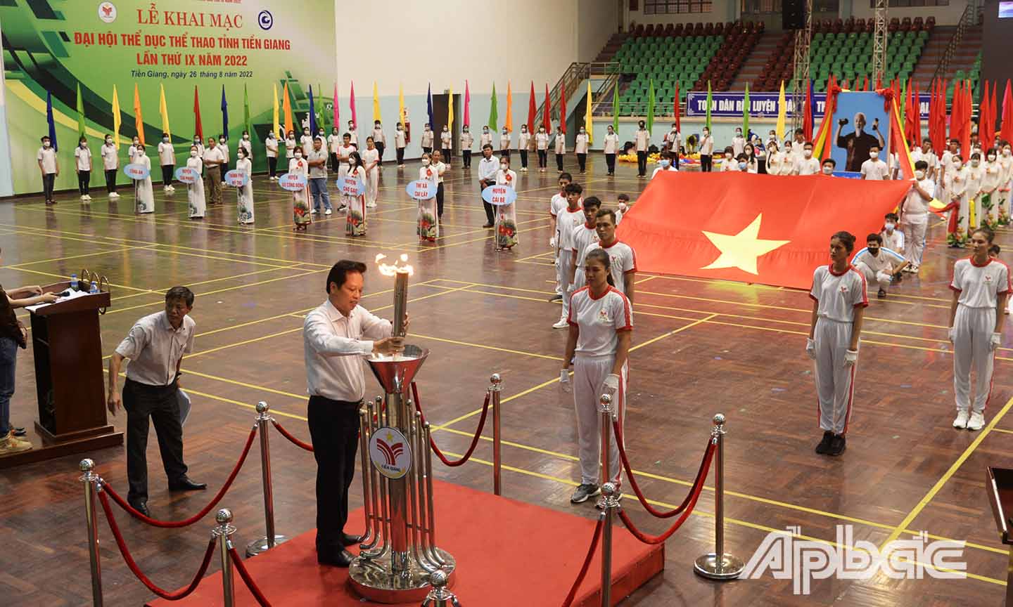 Đồng chí Nguyễn Thành Diệu thực hiện nghi thức thắm đuốc đại hội tại buổi biểu diễn báo cáo.