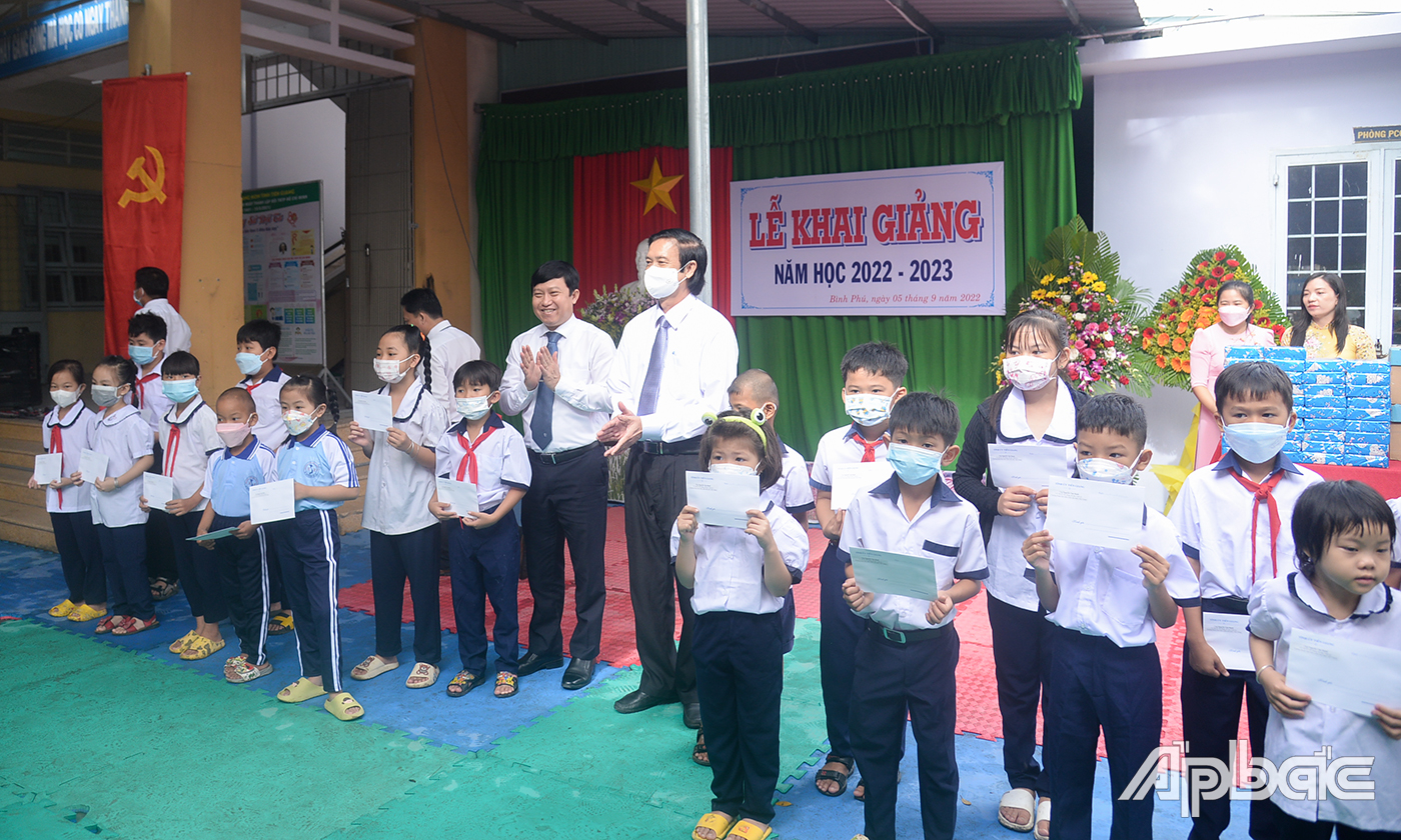 Đồng chí Nguyễn Văn Danh và đồng chí Lê Quang Trí trao học bổng cho các học sinh có hoàn cảnh khó khăn.
