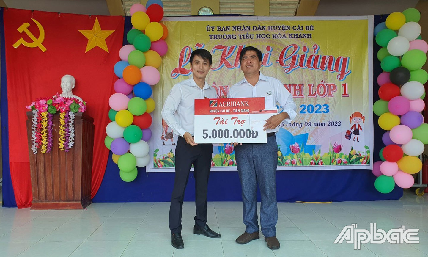 Đại diện Agribank huyệnCái Bè trao biển tượng trưng số tiền ủng hộ cho đại diện Trường Tiểu học Hòa Khánh.